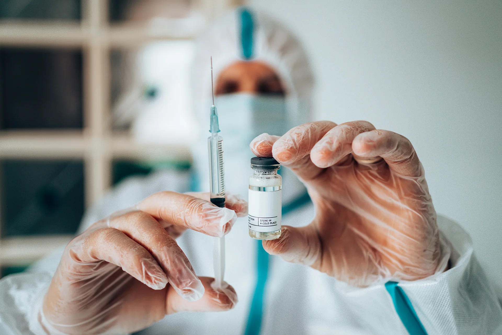 Medical provider holding a syringe and a vial of vaccine