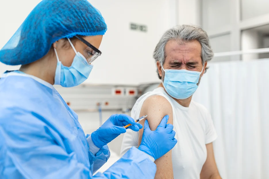 a doctor injected covid vaccine to an elderly man