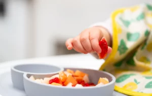 a toddler picking out a slice of fruit