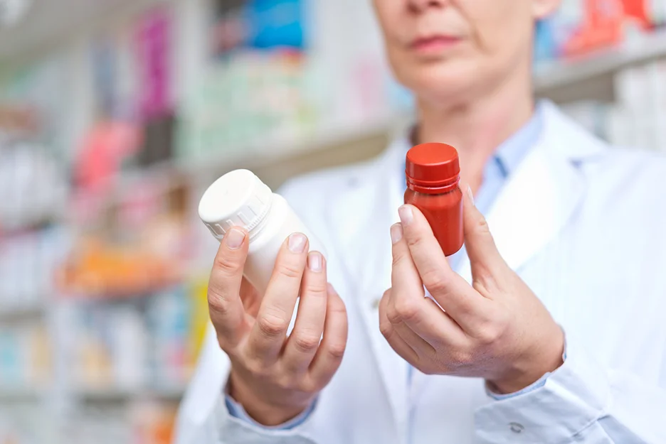 a pharmacist checking two pill bottles