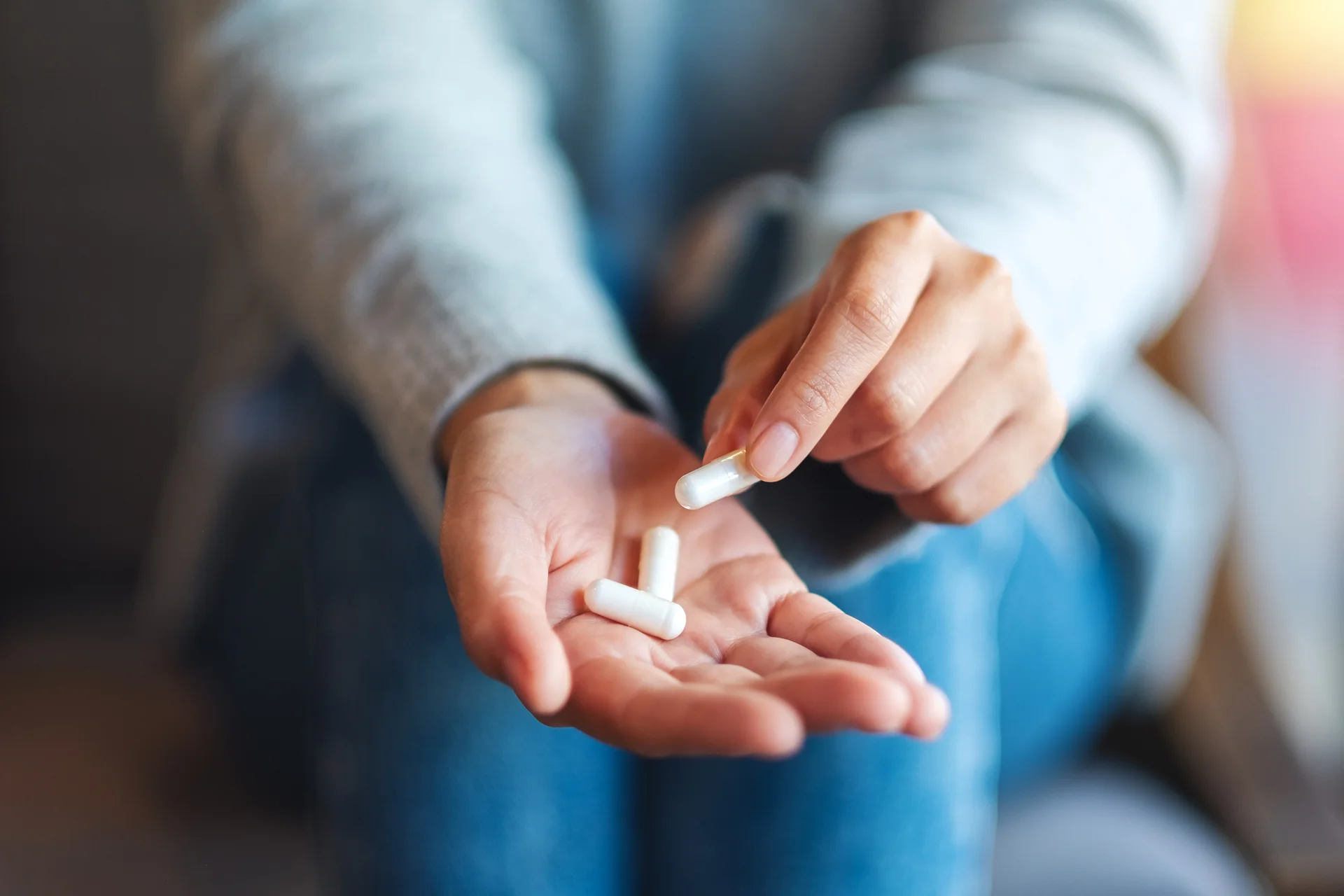 a woman holding and picking white pills