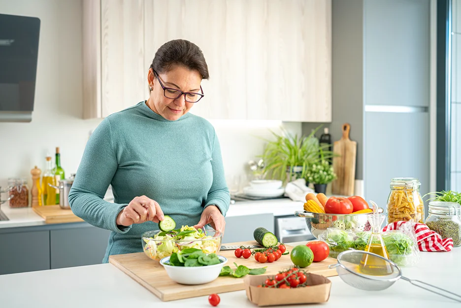 matured woman preparing vegetable salad